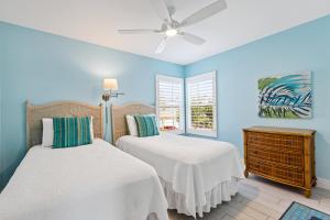 una camera da letto con due letti e un ventilatore a soffitto di Beach Life! Two Heated Pools, Sleeps 19 - FMB - Sweet Summer - Roelens a Fort Myers Beach Altre 72 foto