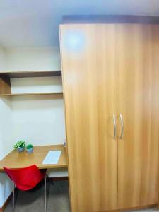 een bureau en een kast in een kantoor met een rode stoel bij Flat Comfort Hotel Taguatinga 906 in Brasilia