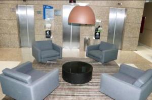een lobby met 2 stoelen en een tafel in een gebouw bij Flat Comfort Hotel Taguatinga 906 in Brasilia +2 foto's