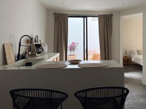 una cucina con isola con due sedie e piano di lavoro di Casa 821 Guest House a Città di Oaxaca