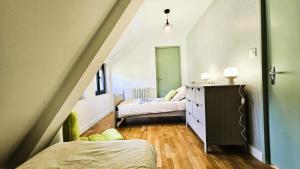 a bedroom with two beds and a dresser in a attic at Gîte de France La maroussie 3 épis - Gîte de France 11 personnes MAE-5091 in Salon-la-Tour
