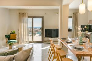 un soggiorno con tavolo, sedie e televisione di Villa Oro di Agathera Kefaloniaprivatevillas ad Argostoli