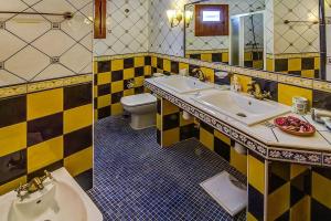 a yellow and black bathroom with a sink and a toilet at Finca La Hoya 1-Tradition trifft Moderne- Meerblick, Whirlpool & Wintergarten-2 Personen in Las Cruces +33 photos