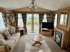 a living room with a couch and a tv at 28 The Beeches in Wigton