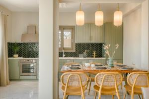 una cucina con tavolo in legno e sedie intorno di Villa Oro di Agathera Kefaloniaprivatevillas ad Argostoli