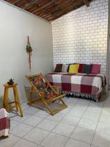 a room with a bed with colorful pillows on it at Aluguel Temporada em Martins/RN in Martins
