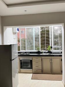 a kitchen with a white refrigerator and a sink at Centre D'estivage Imi Ouaddar in Agadir nʼ Aït Sa +10 photos