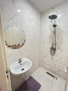 a white bathroom with a sink and a mirror at Centre D'estivage Imi Ouaddar in Agadir nʼ Aït Sa