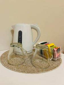 a tea pot and two glass mugs on a table at Casa Flora in Biella