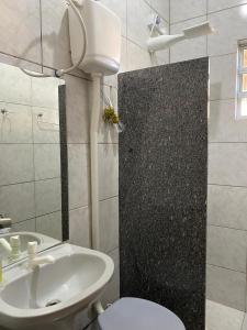 a bathroom with a white toilet and a sink at Aluguel Temporada em Martins/RN in Martins