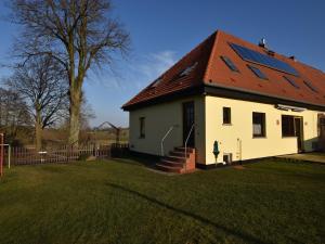 ein kleines weißes Haus mit einem roten Dach in der Unterkunft Snug Apartment in Kröpelin Germany in Klein Nienhagen