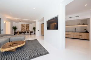 a living room with a couch and a table at Aora Villa Ftelia Beach Mykonos in Panormos Mykonos