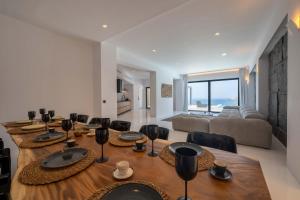 a dining room with a large wooden table and chairs at Aora Villa Ftelia Beach Mykonos in Panormos Mykonos