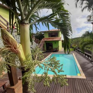 a villa with a swimming pool and a palm tree at Buzios Casa #6 in Búzios