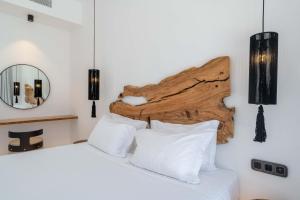 a bedroom with a bed with a wooden headboard at Aora Villa Ftelia Beach Mykonos in Panormos Mykonos +29 photos