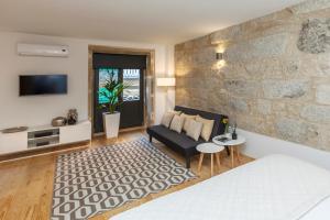 een woonkamer met een bank en een tv bij Oporto Local Studios in Porto