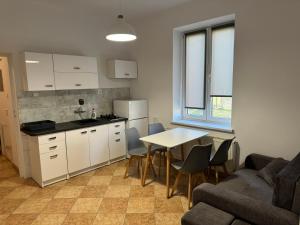 Una cocina y una sala de estar con una mesa y un sofá. en Apartamenty 649 metrów od Dworca, en Przemyśl
