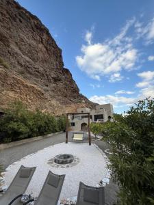 MashūqTilal Al-Qattara的山前带椅子和火坑的庭院