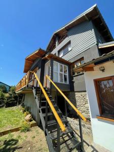 a house with yellow stairs in front of it at Increíble vista al Lago, Casa vacacional "Las Victorias Sur" in San Carlos de Bariloche