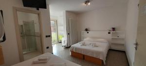 a hotel room with two beds and a shower at Hotel Marbella in Cervia