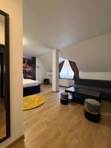 Zimmer mit einem Bett, einem Sofa und einem Hocker in der Unterkunft Casa Mignon in Oradea