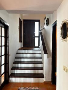 einen Flur mit einer Treppe, die zu einer Tür führt in der Unterkunft Casa Mar y Carmen in Las Negras