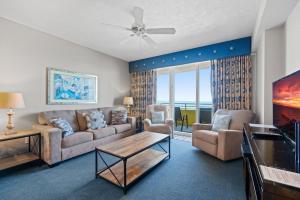 デイトナビーチにあるSeaside Splendor! 1BR Oasis with Private Oceanfront Balcony at Wyndham Oceanwalkのソファとテーブルのあるリビングルーム