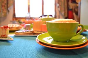 a green coffee cup sitting on top of a table at B&B Un mare di Gioia in Porto Recanati