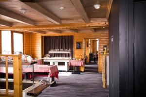 a dining room with wooden walls and wooden floors at Hotel Emeraude in Peisey-Nancroix