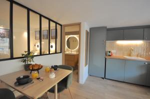 cocina y comedor con mesa y barra en MONACO # MENTON - 4 PERSONS - HYPERCENTER - BEACH AND SUN - PRIVATE PARKING - CLIM - FULL RENOVATED - FAST WIFi, en Menton