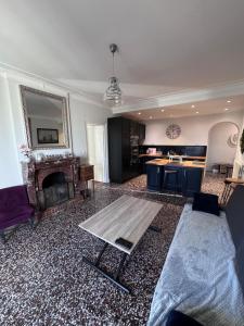 a living room with a table and a fireplace at Super appartement proche Disney in Quincy-Voisins