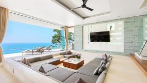 ein Wohnzimmer mit einem großen Sofa und einem Fernseher in der Unterkunft Lime Samui 10: Perfect for Families and Events in Koh Samui 