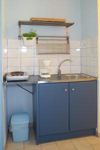- une cuisine bleue avec évier et comptoir dans l'établissement Kalypso Studios & Apartments, à Karavomylos