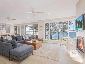 a living room with a couch and a tv at The Lakehouse Retreat in Summerland Point