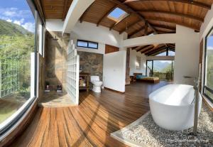a bathroom with a tub and a large window at The Cloud Forest Retreat in Pelagallo