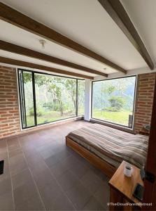 a bedroom with a bed and a large window at The Cloud Forest Retreat in Pelagallo