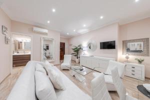 een witte woonkamer met een witte bank en stoelen bij ISG Apartments Jose de Velilla Centro Parking in Sevilla