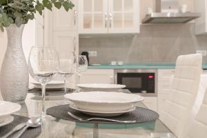 een tafel met wijnglazen en een bord erop bij ISG Apartments Jose de Velilla Centro Parking in Sevilla