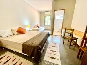 a bedroom with a bed and a chair in it at Pousada Verde Perto - Demétria in Botucatu +19 photos