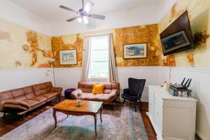 ein Wohnzimmer mit Sofa und Tisch in der Unterkunft Ursulines Historic Creole Cottage (D) Steps to Qtr in New Orleans