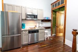 eine Küche mit einem Kühlschrank aus Edelstahl und einer Spüle in der Unterkunft Ursulines Historic Creole Cottage (D) Steps to Qtr in New Orleans + 22 Fotos