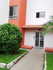 an orange and white building with a door at Quarto casal ARENA OPUS in São José