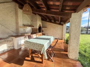 a table and chairs on a patio with a kitchen at Mas Nadal Montseny in Sant Esteve de Palautordera
