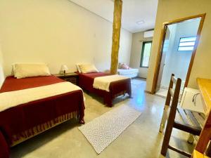 a bedroom with two beds and a mirror at Pousada Verde Perto - Demétria in Botucatu