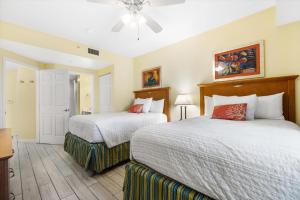 a bedroom with two beds and a ceiling fan at Serene Oceanfront Getaway 1BR with Private Balcony at Wyndham Oceanwalk in Daytona Beach +40 photos