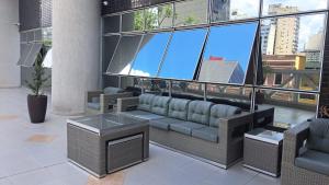 een woonkamer met een bank en een tafel bij Flat Centro de Curitiba Rua 24 horas in Curitiba