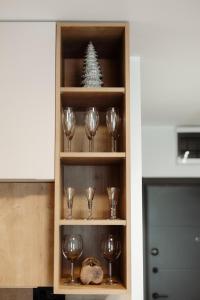 a wine cabinet with wine glasses and a christmas tree at Apartman Nina in Kopaonik +3 photos