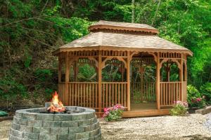 un gazebo in legno seduto accanto a un focolare di Trail Head by Stony Brook Cabins a Gatlinburg