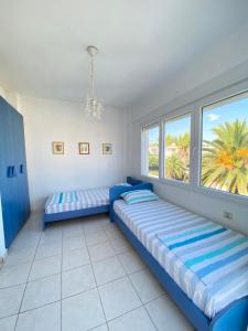 two beds in a room with a window at Olivia sea side house in Hanioti