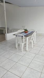 a white table and chairs with a potted plant on it at Casa Aconchegante na praça 14 in Manaus